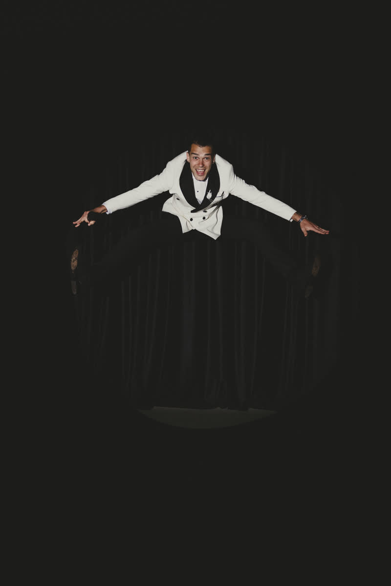 Playful portrait of Vova against a black stage curtain