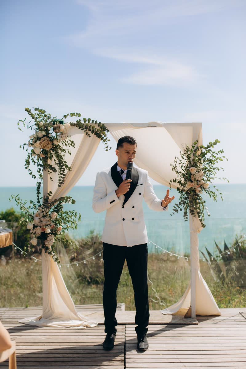 Vova hosting beneath a flower arch overlooking the sea